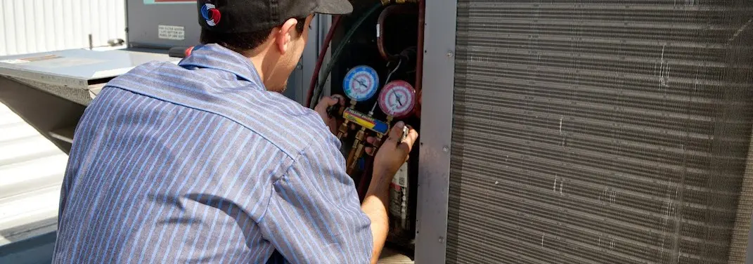HVAC technician servicing a condenser unit in Haslet